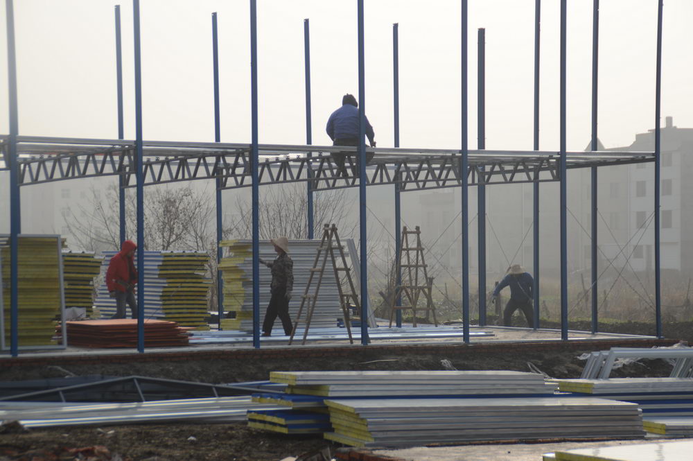 百里.太子湾2016年12月工程进度工人正在固定板房结构